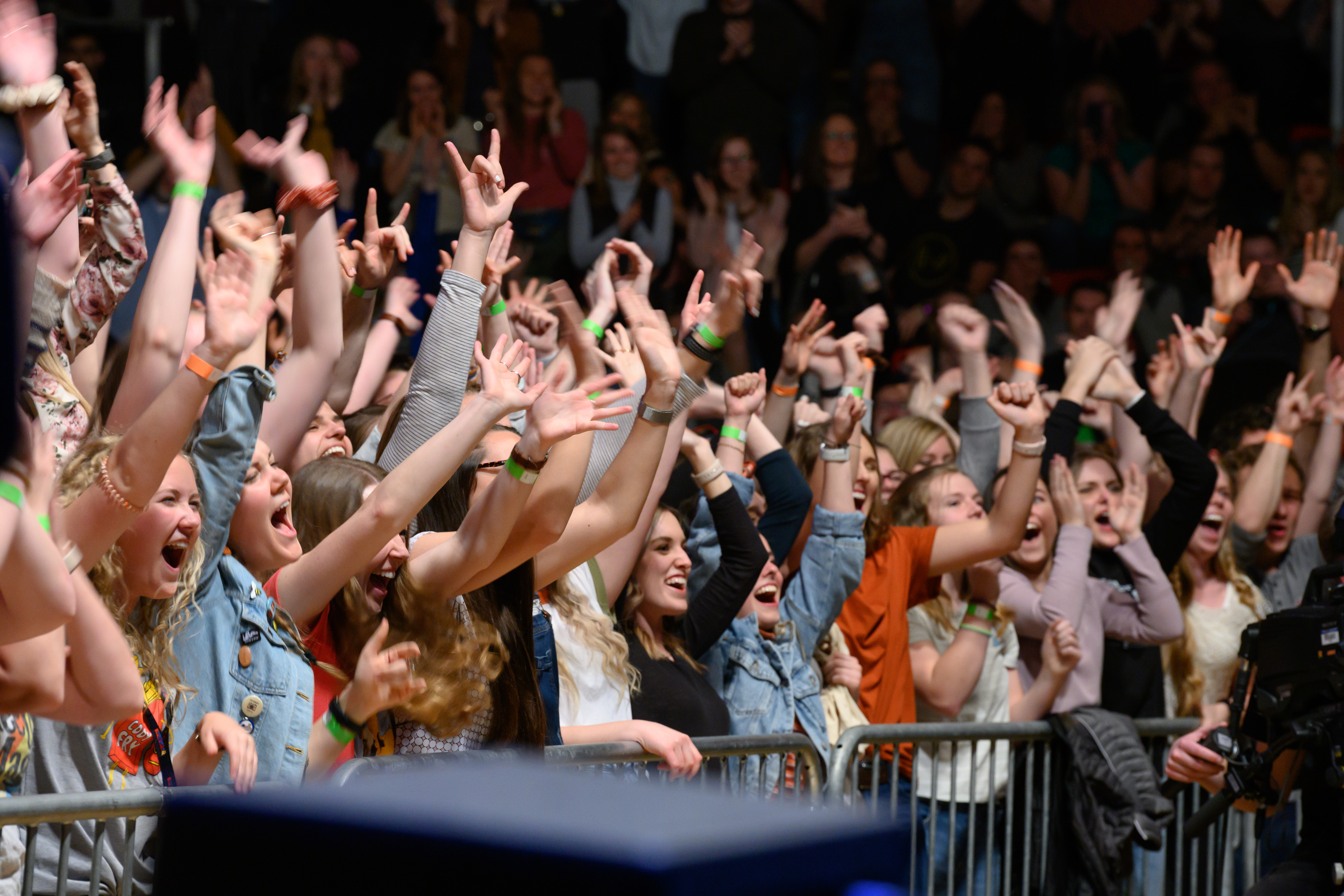 A group of students raise their arms and shout at a Ben Rector and Cody Fry concert in March 2020
