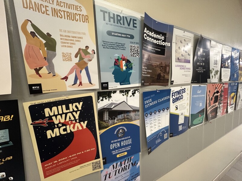 Various BYU-Idaho event posters displayed along a wall on the first floor in the Manwaring Center