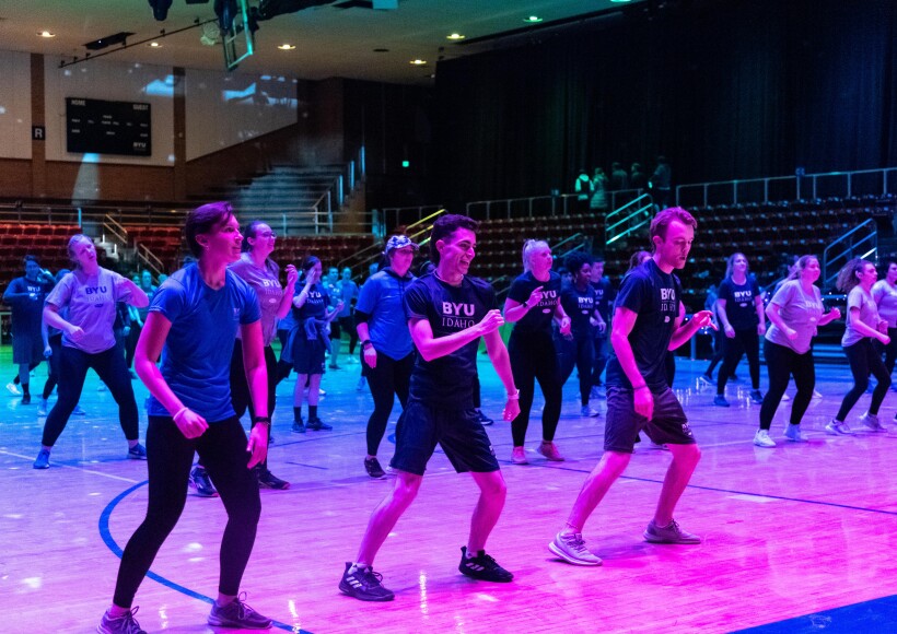 Students participating in the Winter 2023 Fitness Kickoff event, doing a fitness dance in the gym.