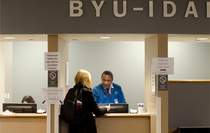 Male Health Center Employee processing a patient information