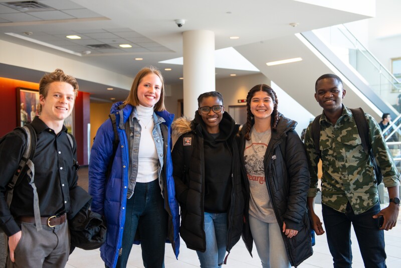 A group of Students in the I-Center, smiling at the camera before the devotional 