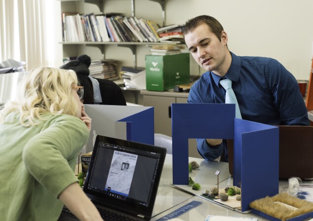 Two students build 3d models in one of their graphic design classes.