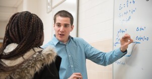 Students write on a whiteboard to solve problems in a Physics Class.