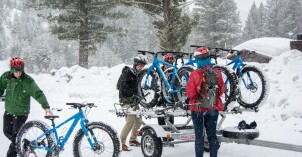 Students take bikes off of a trailer in the snow to go Fat Tire Biking.