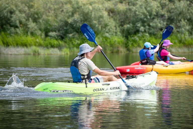 Idaho has some of the best rivers in the U.S. Several student kayak on a river as part of a student life activity.