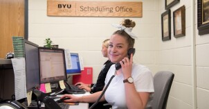 A student answers calls in the Scheduling Office
