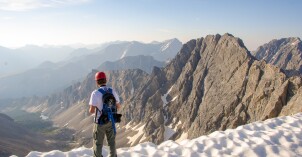 Mountaineering man stands on the edge of a cliff.
