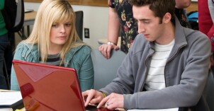 Students gather around a computer to complete an assignment for FDMath 110.