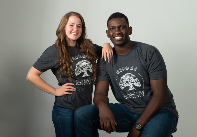 Two students pose in Be Mighty T-shirts.