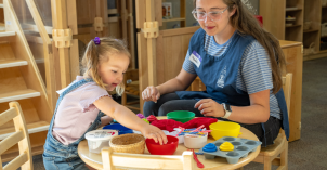 A home and family student plays with a young girl.