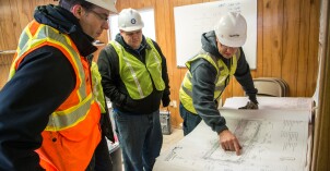 A professor and his students view a construction project during a civil engineering tour.