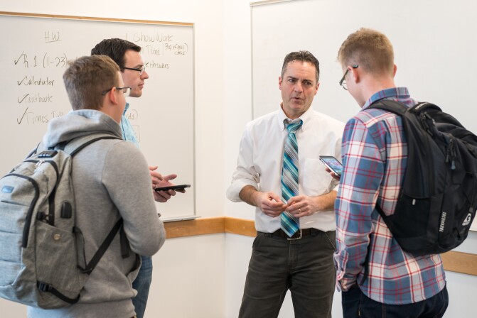 Math Education students talk with a professor.
