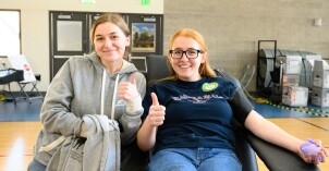 Two BYU-Idaho students smile while donating blood an an I-Serve on-campus blood drive with the American Red Cross.