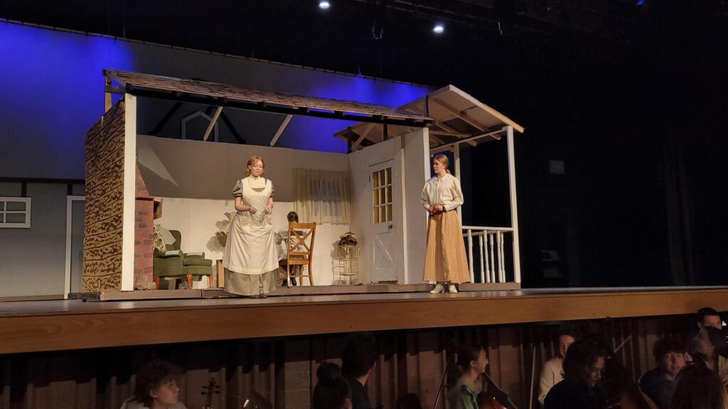 Two women on stage in a house