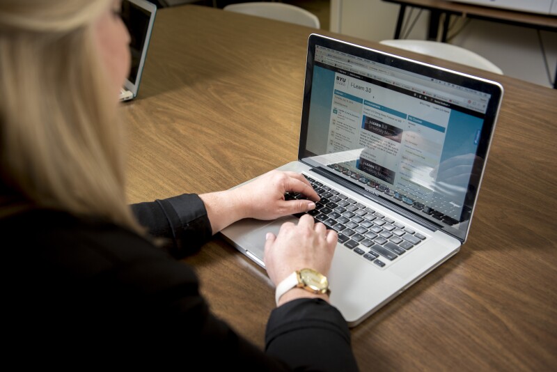 Student using a computer to explore BYU-Idaho's Concurrent Enrollment Credit Transfer Tool, determining how high school courses transfer to university credit.