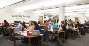 Students sitting at tables, studying at the Tutor Center