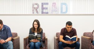 A row of students sitting and reading