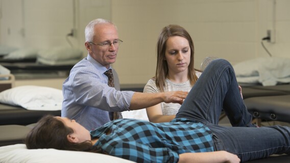 A professor teaches students with hands on experiences in the classroom.
