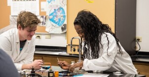 Students prepare petri dishes in a microbiology lab.