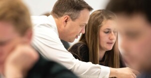Teacher advising student in class