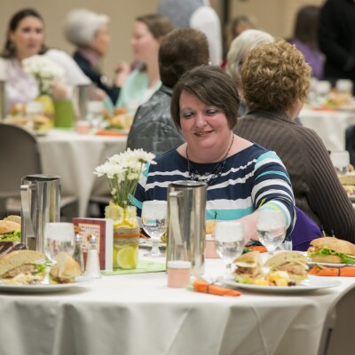 Women sitting at tables enjoying their lunch at the Women's Luncheon