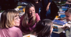 A BYU-Idaho student laughs while leading elementary school children in a learning activity during an I-Serve afterschool program.