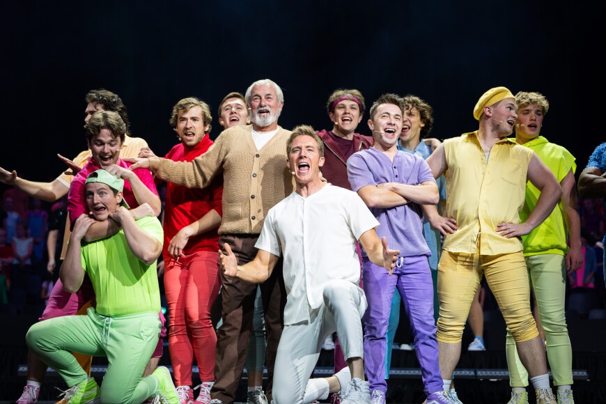Student life is not complete without campus performing arts. BYU-Idaho students sing on a stage in multi-colored costumes in Joseph and the Amazing Technicolor Dream Coat.
