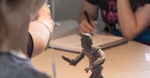 Students work on their projects for class. The project in the image is a 3d figurine.