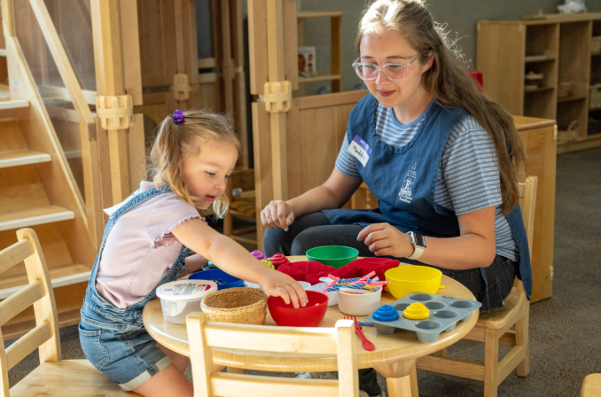 A home and family student plays with a young girl.