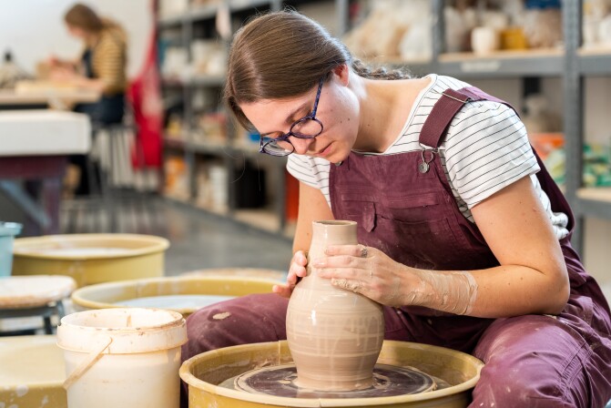 Ceramics student Whitney Carr throwing on the wheel.