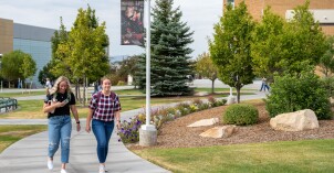 Two students walking on campus near the Manwaring Center