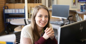 Student employee smiles at camera