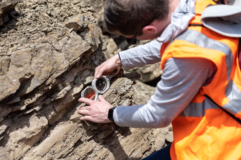 A student examines a rock on a geology field trip