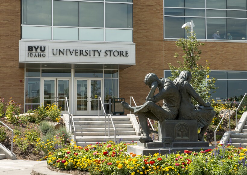 An outside view of the University Store at BYU-Idaho with a statue of two students reading in the foreground.