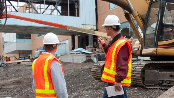 Construction Interns Aaron Howard (red jacket) and Ben Millet inspect the Manwaring Center.