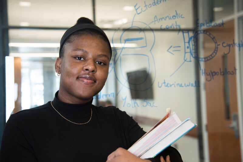 BYU-Idaho Student Ardgine Pierre holding her Biology textbooks