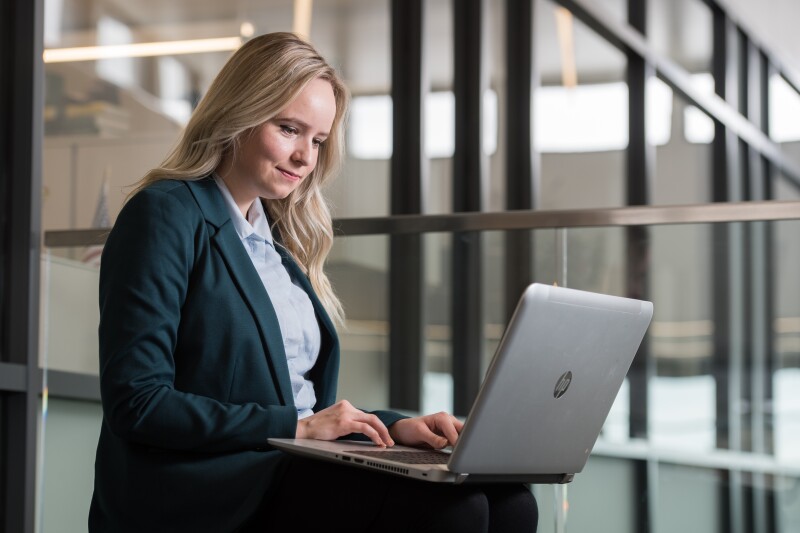 Woman sitting down with a laptop on her lap