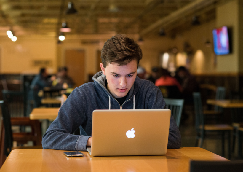 A student watches a video on his laptop