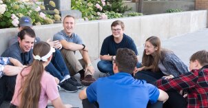 Small group of students meeting with their mentors outside.