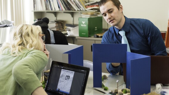 Two students build 3d models in one of their graphic design classes.