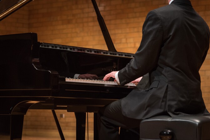 A man plays a Hamburg Steinway Piano in the BYU-Idaho Barrus Hall.