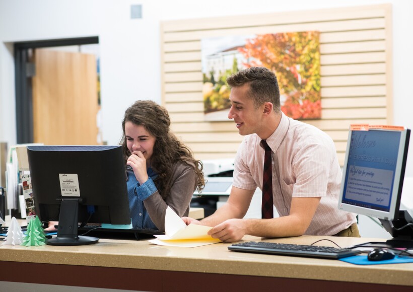 Students work together to help students print assignments at the Express Print and Copy.