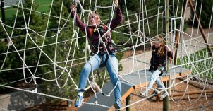 Two girls climbing the ropes