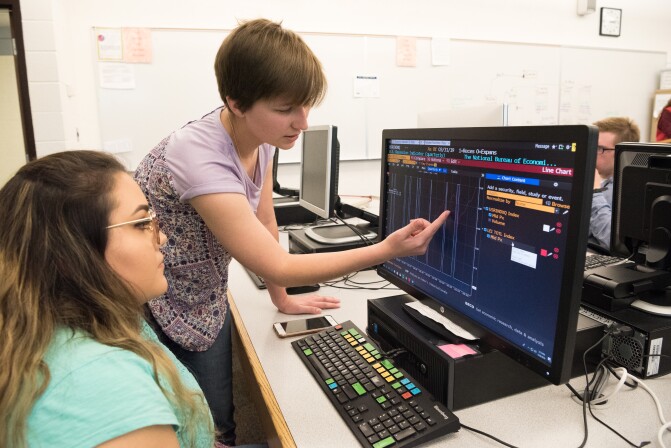 Students work on an assignment with the help of a Bloomberg computer.