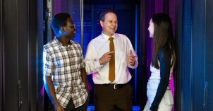 A Computer Information Technology professor speaks with students in the Smith building server room.