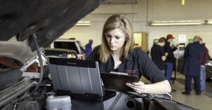 A female BYU-Idaho student working on a car in Auto Class