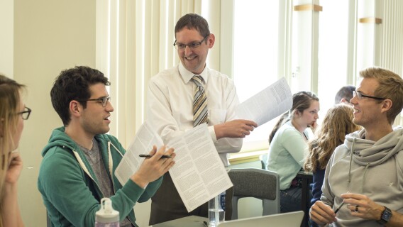 Students talk with a professor about Advanced Graphic Design content.