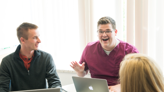 A marriage and family studies student excitedly talks with fellow classmates
