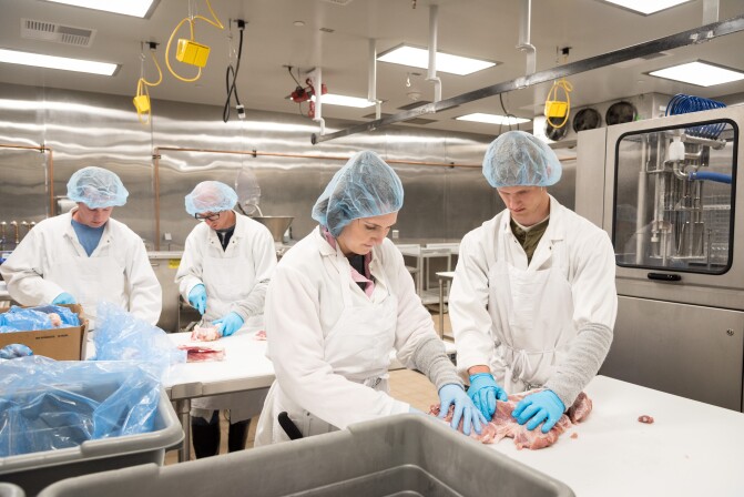 Students trimming meat.