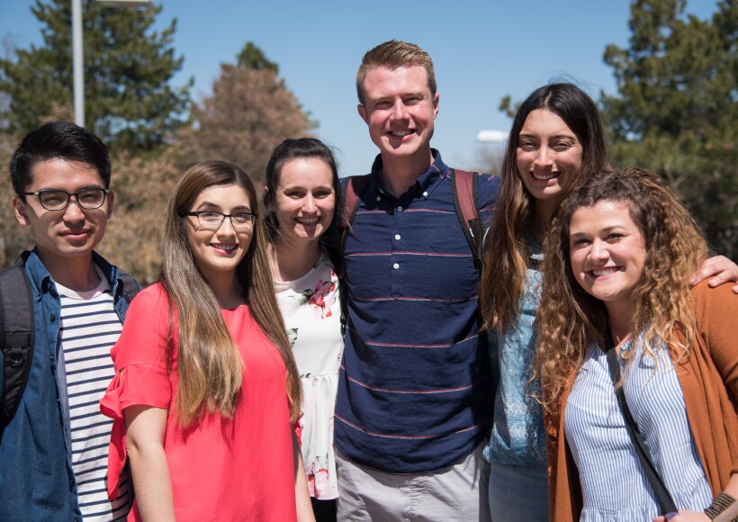 A group of BYU-Idaho students, gathered together on campus, smiling.